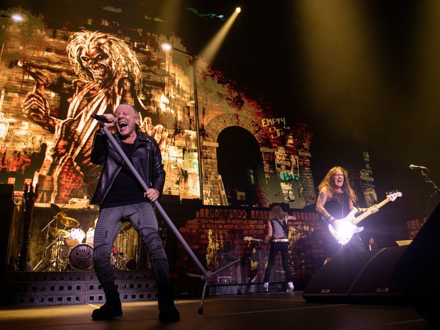 Iron Maiden performing live with Bruce Dickinson and Steve Harris under dramatic stage lighting