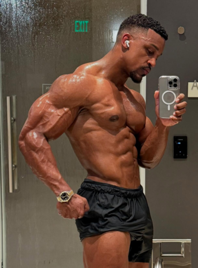 Ashton Hall showing his muscular physique in a gym