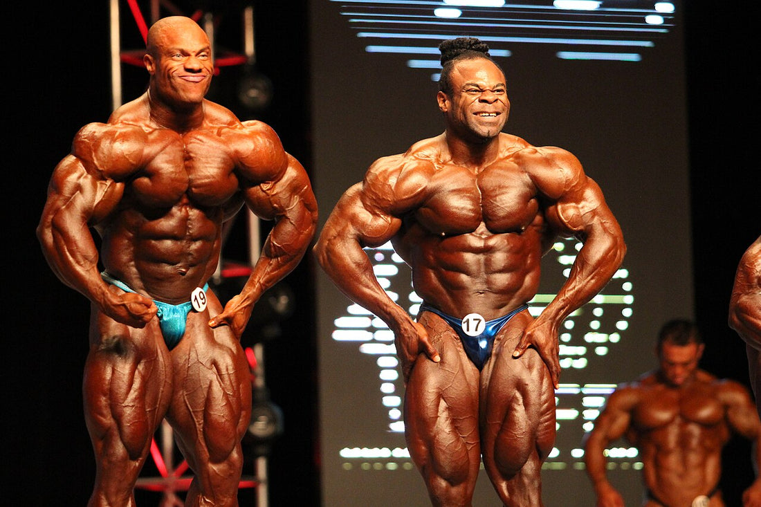Phil Heath and Kai Greene posing side by side at the 2012 Mr. Olympia
