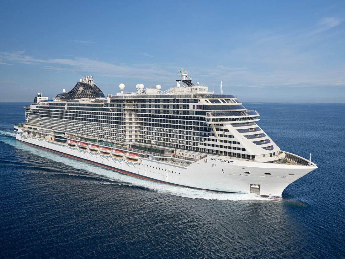 MSC Seascape cruise ship sailing at sea, wide side view of white vessel and blue water