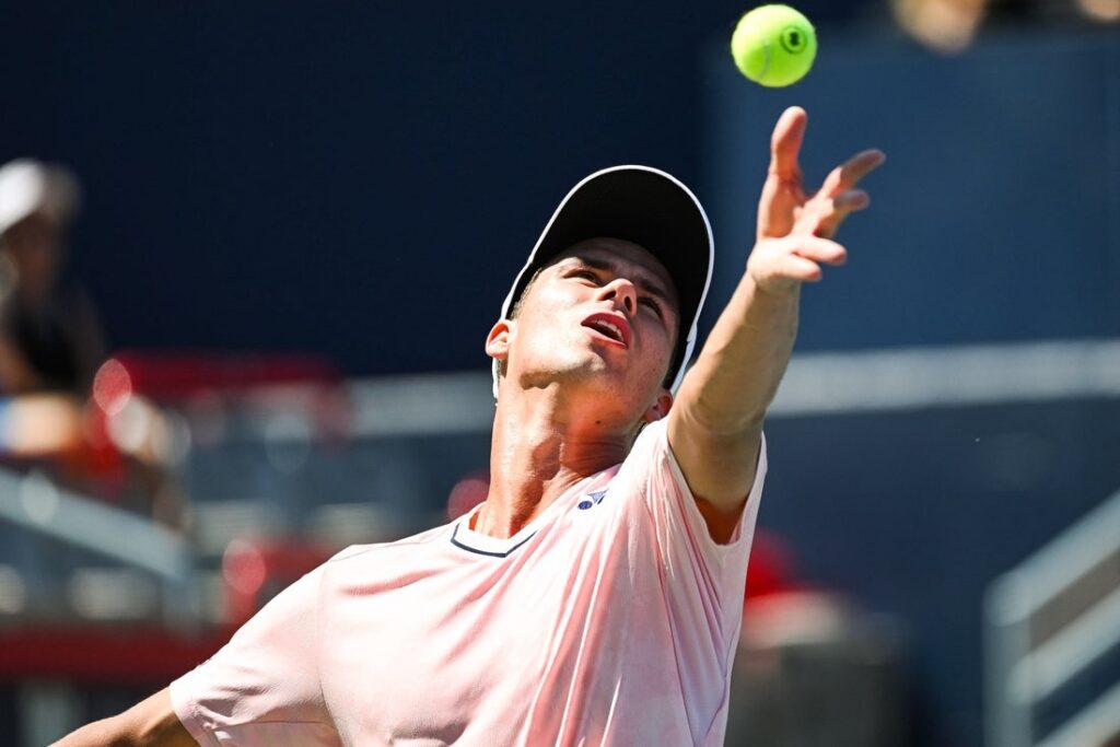 Daniel Altmaier serves during a professional hard-court tennis match.