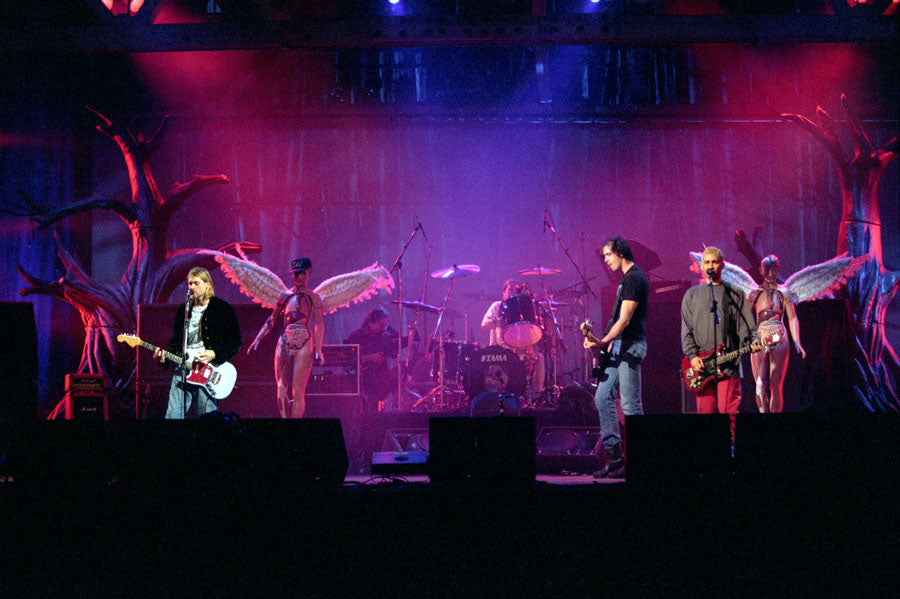 Nirvana performing onstage under purple lighting during a high-energy 1993 concert