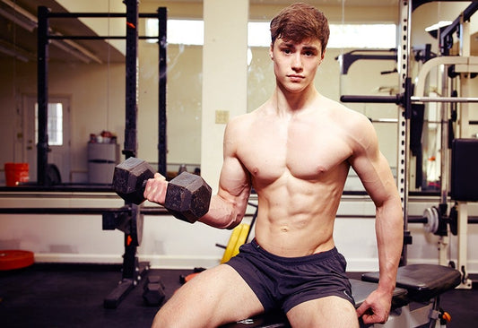 David Laid posing with a dumbbell in a gym during the early years of his influential lifting videos