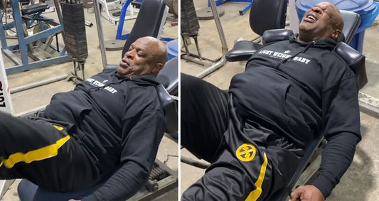 Ronnie Coleman wearing a black Light Weight Baby hoodie while training on a leg press in the gym