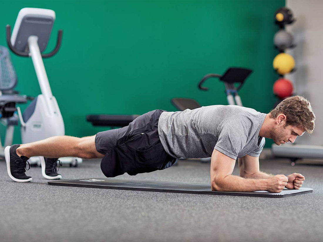 An athlete performing a controlled forearm plank with a straight trunk and engaged abdominal muscles