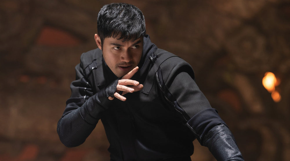 Henry Golding in black Snake Eyes training costume adopting a martial-arts stance