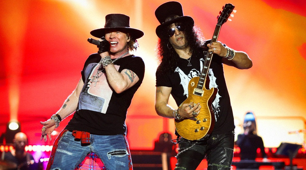 Axl Rose singing beside Slash playing guitar during a Guns N' Roses concert