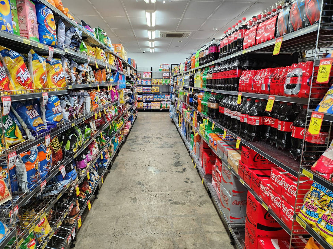 Supermarket aisle filled with brightly packaged potato chips and bottled soft drinks
