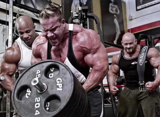 Jay Cutler performing a heavy barbell row in a gym with spotters nearby