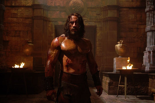 Dwayne Johnson as Hercules shirtless in a torchlit stone temple