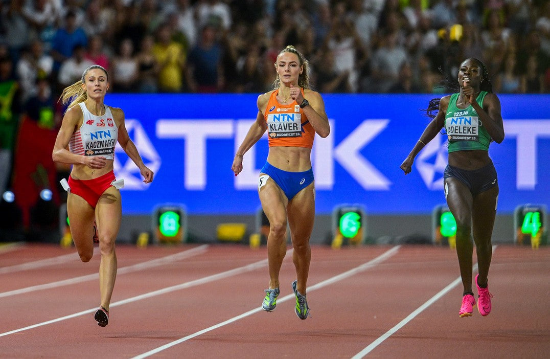 Three female 400m runners racing on a red track at the 2023 World Athletics Championships in Budapest