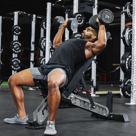 Muscular athlete performing an incline dumbbell press in a gym