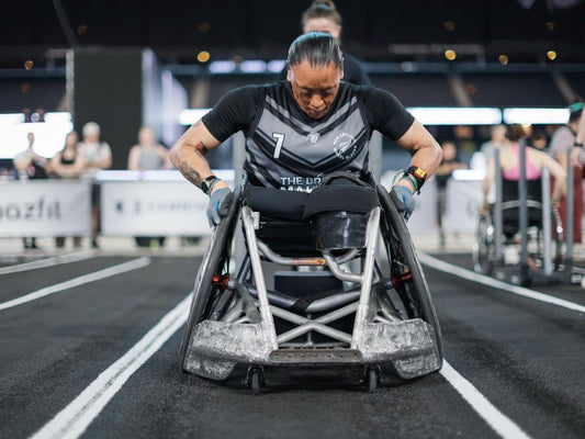 Wheelchair athlete competing on a HYROX indoor race course; illustrative adaptive competition photograph, not the Ukrainian Valencia team