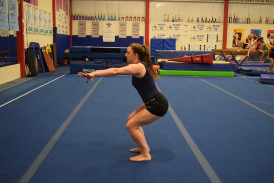 Illustrative gymnastics training image showing a female athlete practicing a controlled landing; not a photograph of the 2026 world final