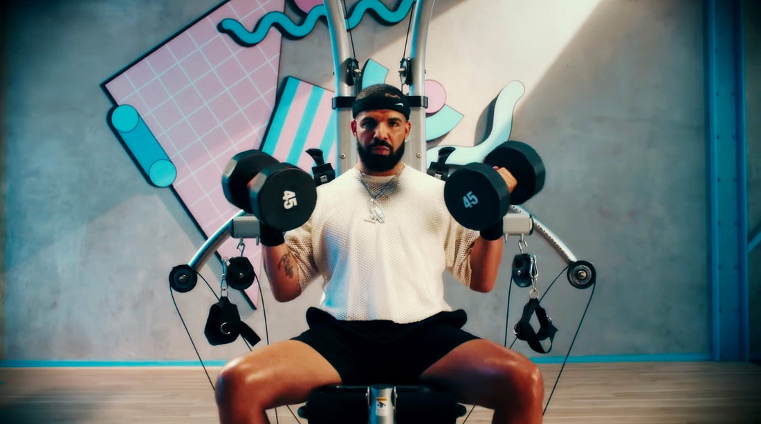 Drake performing arm-focused weight training in a gym