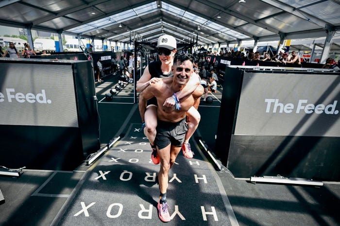 Two HYROX blind-date mixed doubles athletes celebrating together after their race