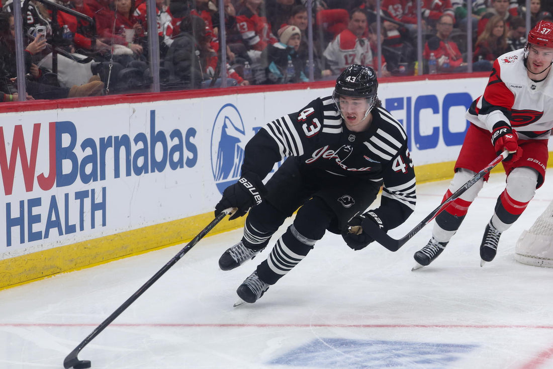 Luke Hughes skating in a New Jersey Devils black alternate jersey