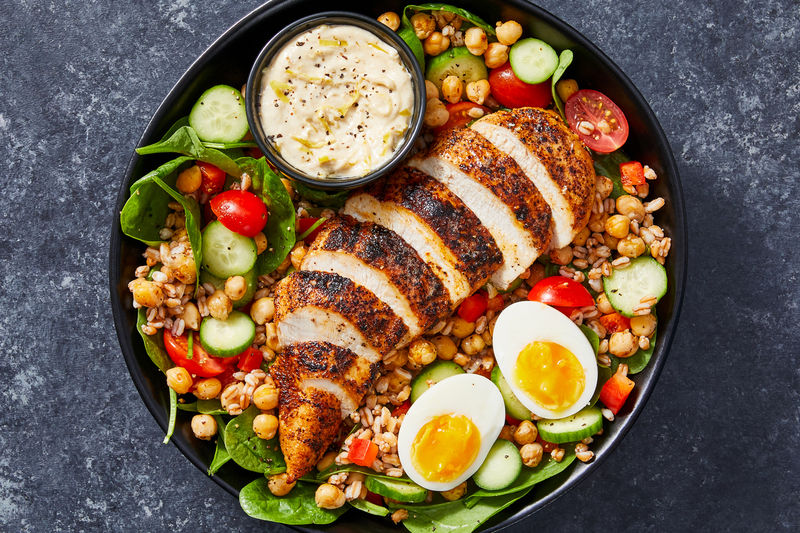 Grilled chicken salad with chickpeas, greens, vegetables and boiled eggs