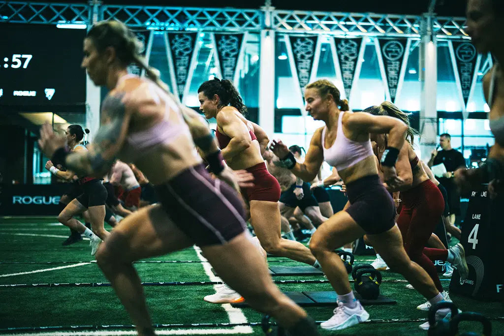 Women sprinting across green turf during the 2026 98 Games team fitness competition in Sydney
