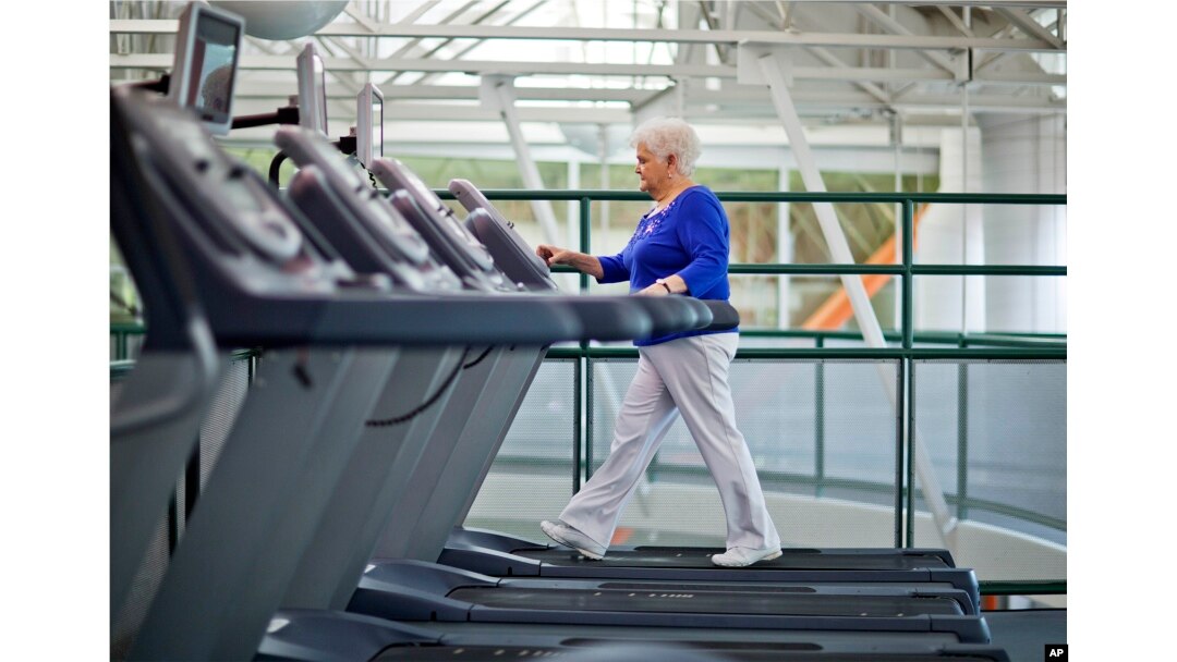 Older woman walking on a treadmill in a gym