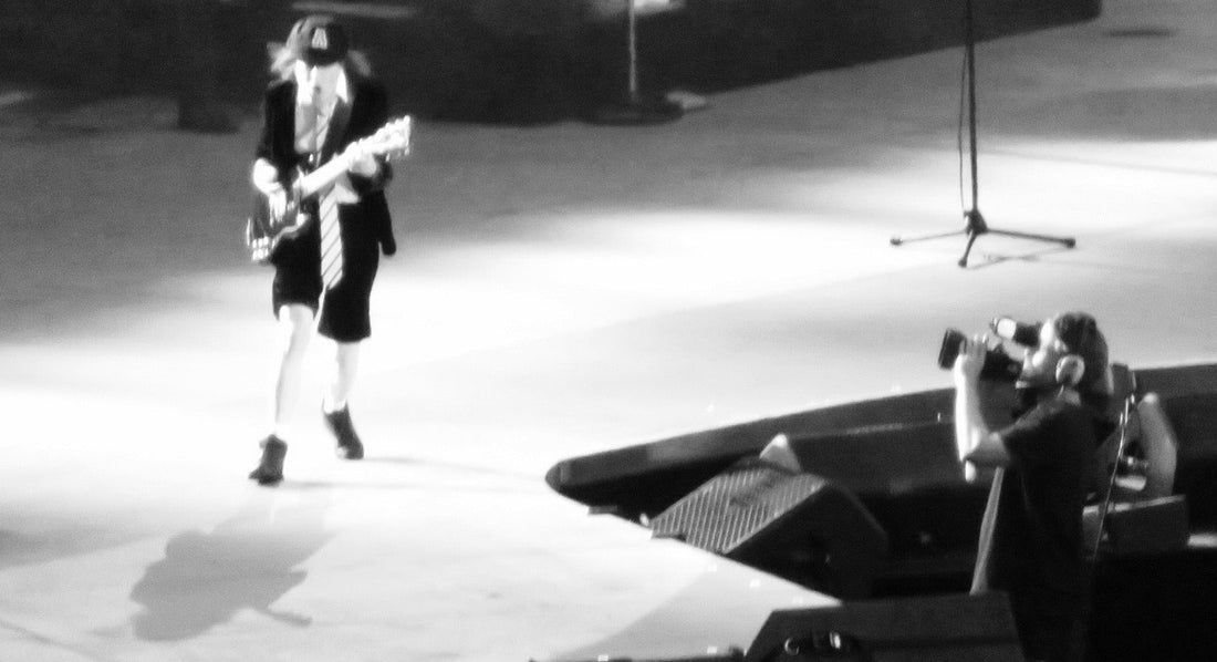 Angus Young performing with AC/DC as a runner trains, illustrating AC/DC albums for cardio