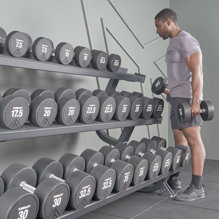 Lifter selecting an appropriate dumbbell from a gym rack