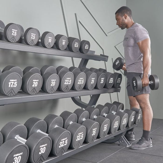 Lifter selecting an appropriate dumbbell from a gym rack