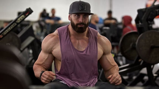 Bradley Martyn training in a purple tank top inside a busy weight room