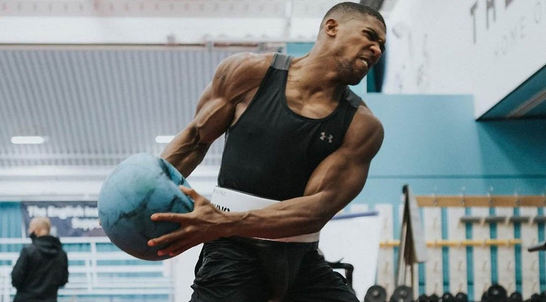 Anthony Joshua performing an explosive rotational medicine-ball exercise during boxing preparation
