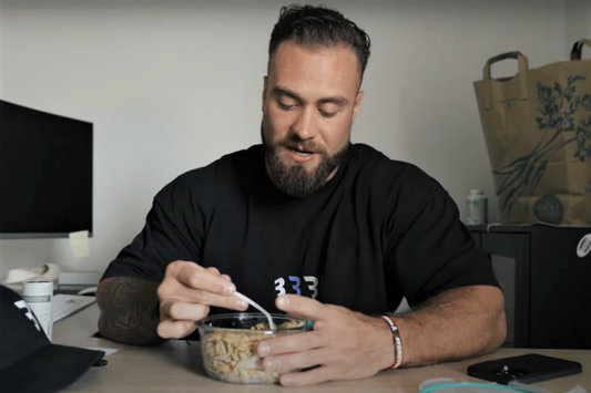 Chris Bumstead seated at a table eating a prepared off-season meal