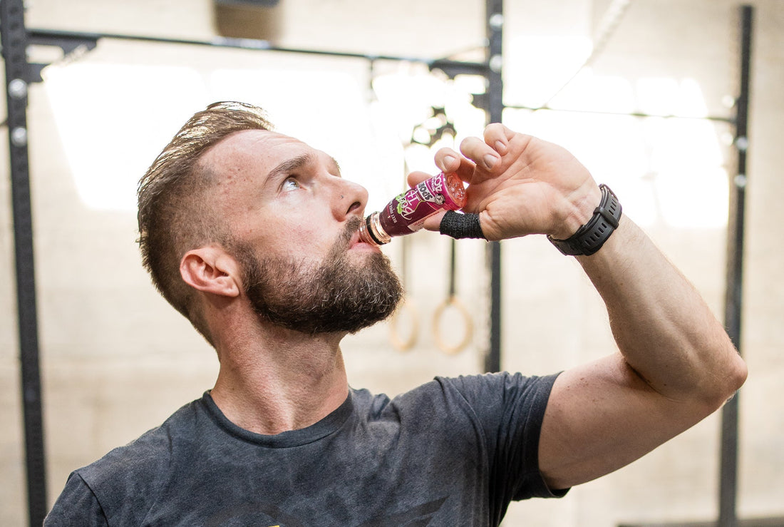 Athlete drinking a beetroot juice shot during training, illustrating research on nitrate and resistance exercise
