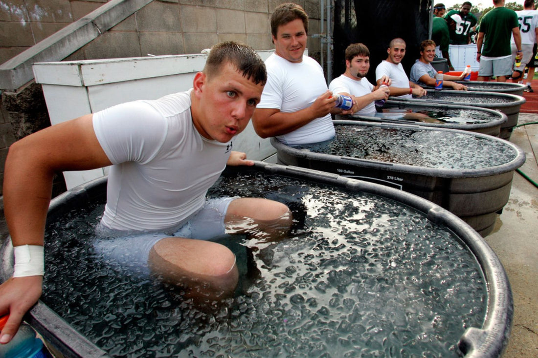 Athletes sitting in outdoor tubs of icy water after training