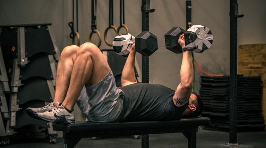 Dumbbell bench press in a dark training gym