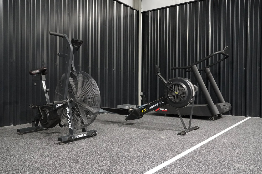 Real training gym with an air bike and rowing machine side by side, authentic fitness equipment, no text overlay