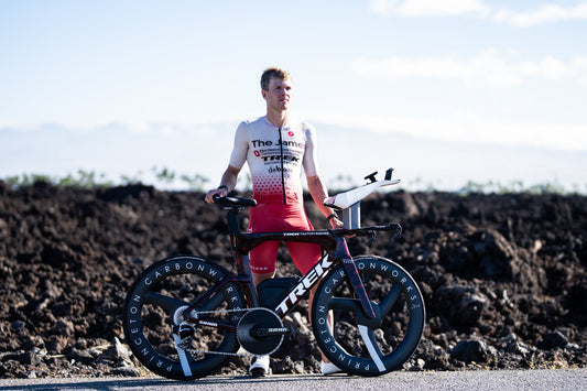 Matthew Marquardt stands beside his Trek time-trial bicycle on the Kona lava fields ahead of the 2026 Ironman World Championship