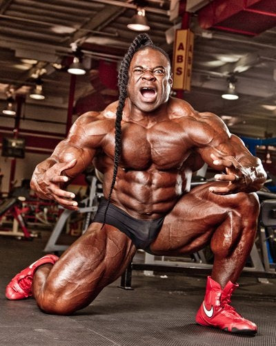 Kai Greene posing intensely in an old-school bodybuilding gym