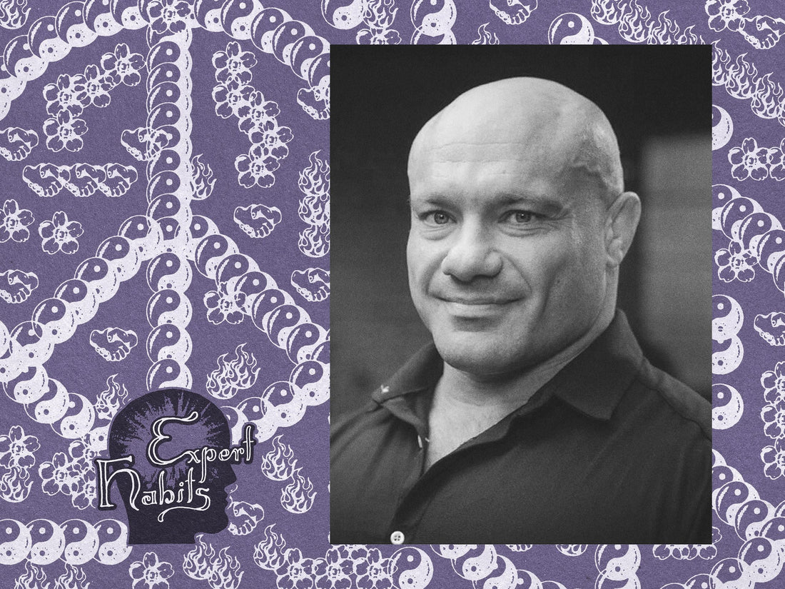 Black-and-white portrait of Mike Israetel on a purple patterned editorial background