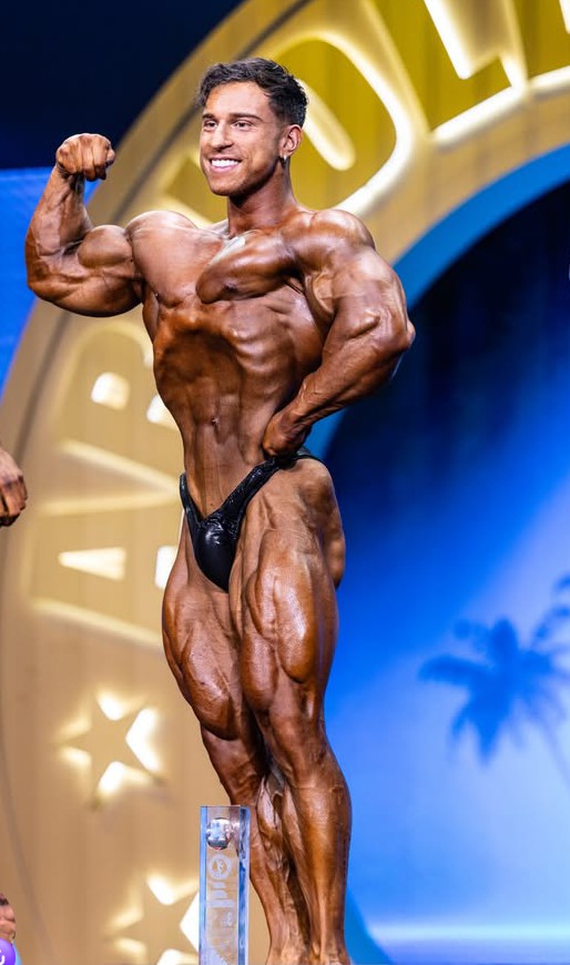 Archival March 2026 Arnold Classic stage photograph of Andrea Mammoli striking a Classic Physique pose