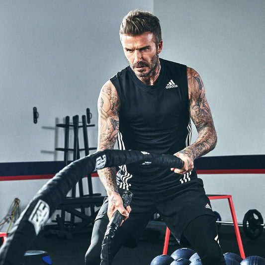 David Beckham working battle ropes in a gym, showing athletic upper-body conditioning