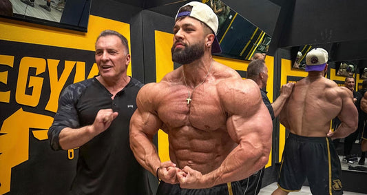 Milos Sarcev coaching a professional bodybuilder in a gym