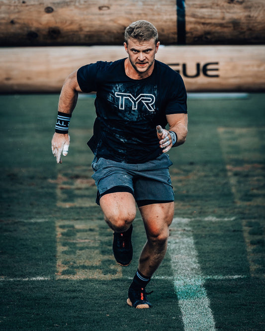 Dallin Pepper sprinting in a black TYR training shirt on a grass field