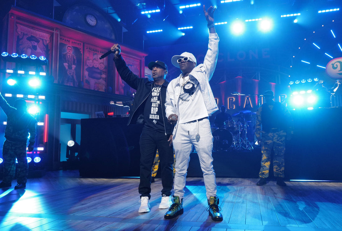 Chuck D and Flavor Flav of Public Enemy performing together under blue stage lights