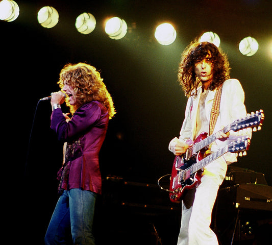 Robert Plant and Jimmy Page performing live with Led Zeppelin under stage lights