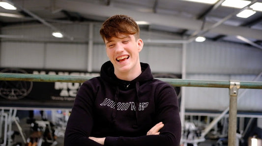Joe Fazer smiling in a black hoodie inside a gym