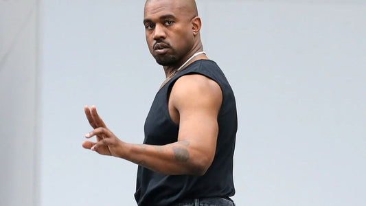 Kanye West in a sleeveless black top with his upper arms visible