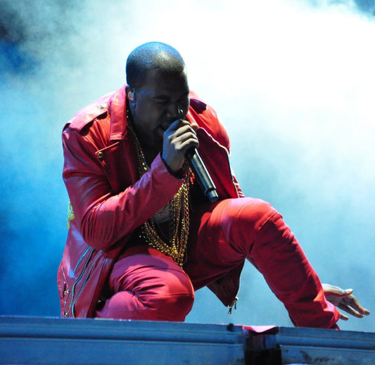 Kanye West performing in a red outfit with a microphone at Lollapalooza Chile in 2011