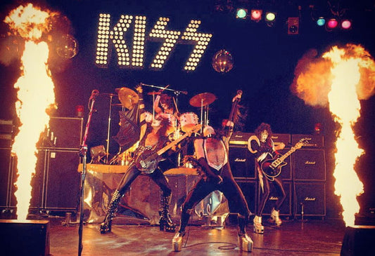 KISS original lineup performing onstage with guitars, drums and stage lights