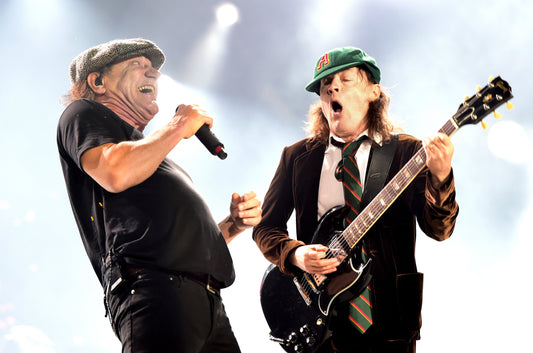 Angus Young and Brian Johnson of AC/DC performing energetically onstage