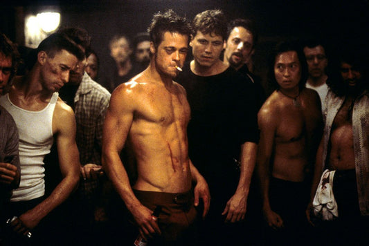 Brad Pitt as Tyler Durden, shirtless among fighters in a Fight Club film scene