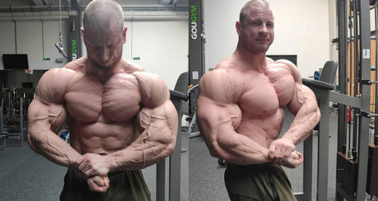 Slovak bodybuilder Michal Krizo showing enormous chest and arm development in a side-chest pose at the gym